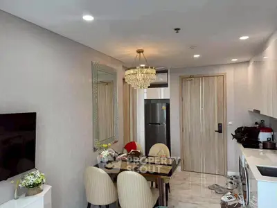 Modern dining area with elegant chandelier and compact kitchen setup.