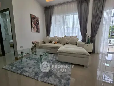 Elegant living room with modern decor, plush sofa, and glass coffee table, perfect for relaxation.
