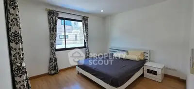 Spacious bedroom with elegant curtains and modern furnishings in a bright, airy apartment.