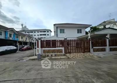 Charming suburban house with gated driveway and spacious parking area, ideal for family living.