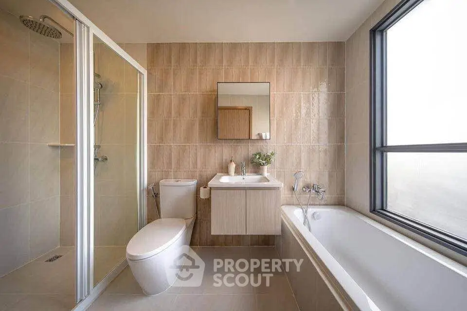 Modern bathroom with sleek design, featuring a shower, bathtub, and large window for natural light.