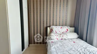 Cozy bedroom with floral bedding and modern wallpaper, perfect for a restful retreat.