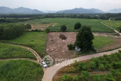 Expansive rural land with lush greenery and scenic mountain views, ideal for development or agriculture.