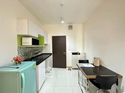 Modern kitchen with sleek cabinetry and compact dining area in a stylish apartment.
