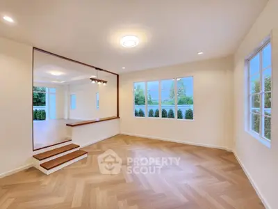 Spacious modern living room with large windows and elegant wooden flooring