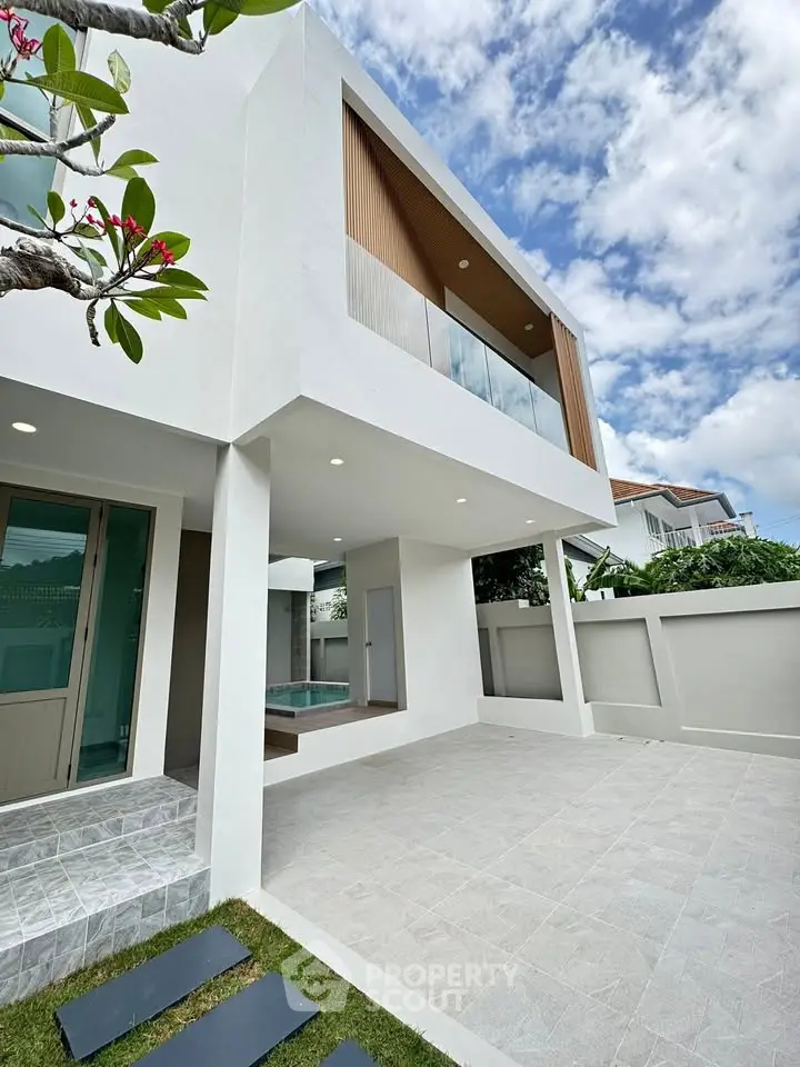 Modern two-story house with spacious patio and elegant architectural design.