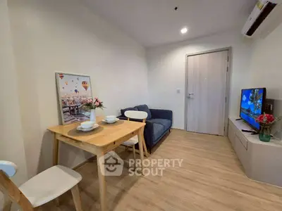 Cozy living room with dining area, modern decor, and wooden flooring in a stylish apartment.