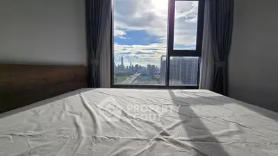Spacious bedroom with stunning city skyline view through large window.