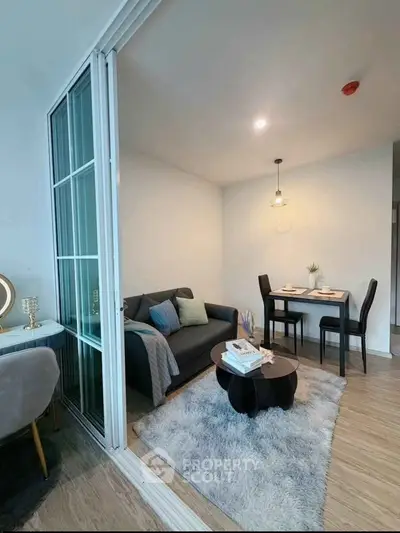 Modern living room with cozy seating and dining area, featuring stylish decor and ambient lighting.