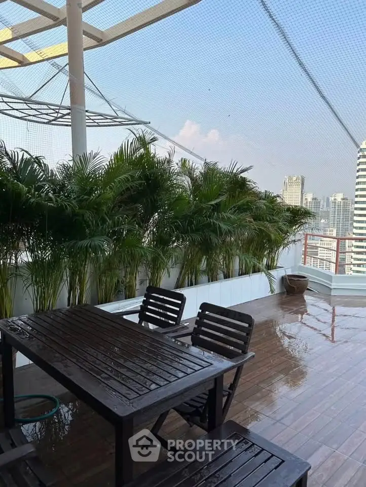 Stunning rooftop terrace with lush greenery and city skyline views, perfect for outdoor relaxation.