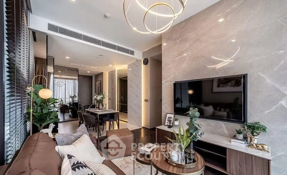 Luxurious modern living room with elegant decor and open layout, featuring stylish lighting and a large TV.