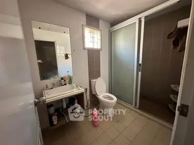 Spacious bathroom with modern shower and ample storage space.