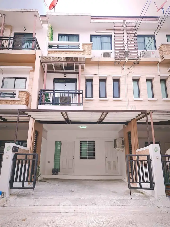 Modern townhouse exterior with covered parking and balcony, ideal for urban living.