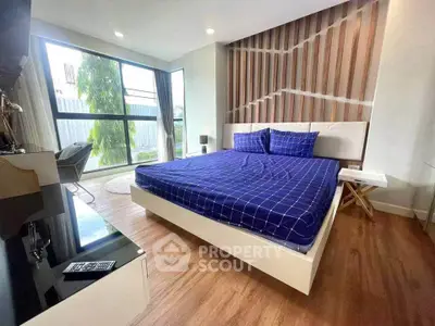Spacious modern bedroom with large window and stylish decor