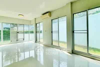 Spacious sunlit room with large windows and garden view