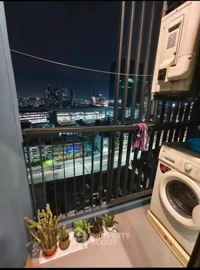 Charming balcony with city view, washing machine, and potted plants, perfect for urban living.
