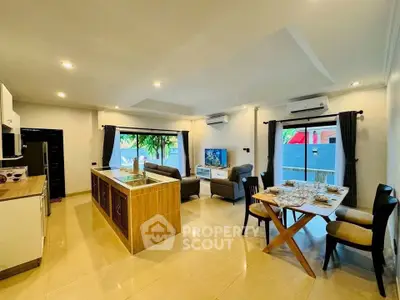 Spacious open-plan living room with modern kitchen and dining area, featuring elegant decor and ample natural light.