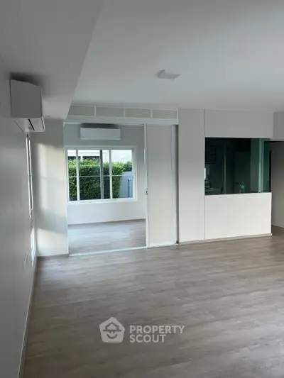 Spacious modern living room with large windows and sleek flooring