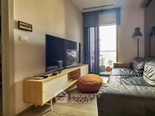 Cozy living room with modern TV setup and balcony access