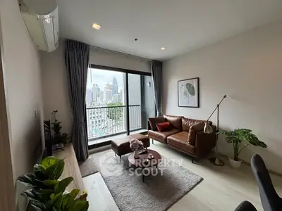 Modern living room with city view, stylish decor, and cozy seating area.