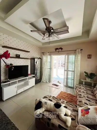 Charming living room with modern decor, cozy seating, and natural light from large windows.