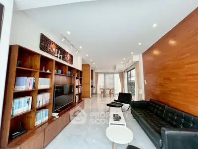 Spacious modern living room with sleek furniture and built-in wooden shelving.