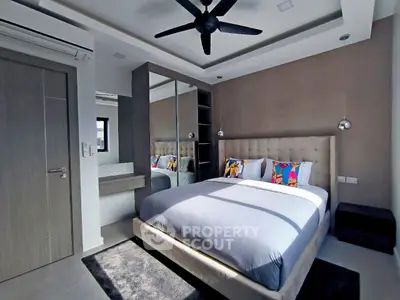 Modern bedroom with stylish decor, large bed, and ceiling fan in a contemporary apartment.