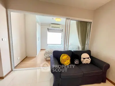 Modern apartment with cozy living room and sliding doors to a bright bedroom, featuring stylish decor.
