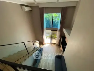 Modern loft-style living room with high ceilings and large windows