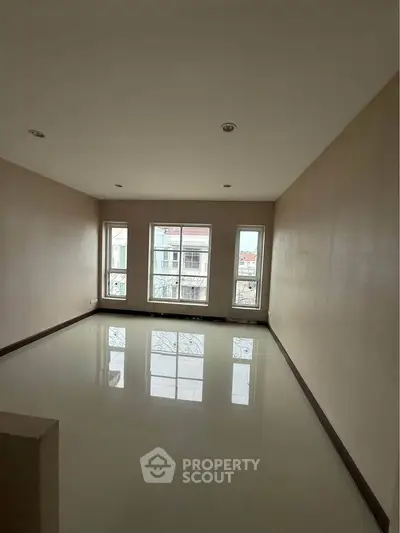 Spacious empty room with large windows and glossy floor, ideal for customization.