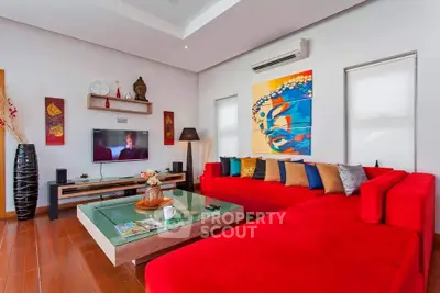Stylish living room with vibrant red sofa and modern decor, perfect for relaxation and entertainment.