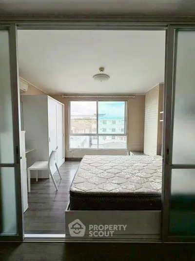 Modern bedroom with large window and minimalist furniture design.