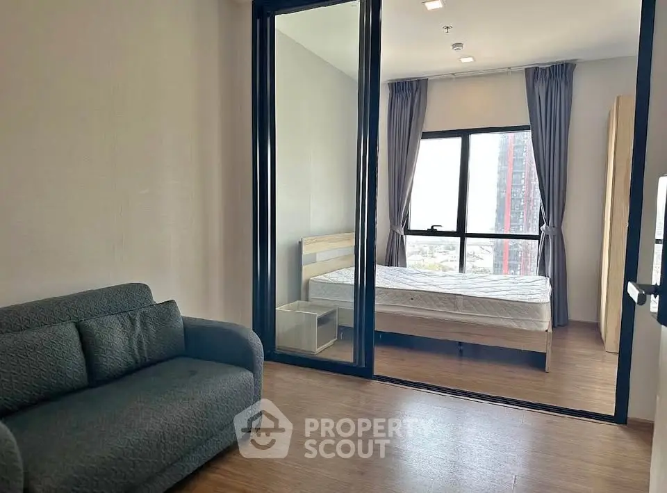 Modern apartment with cozy bedroom and living area, featuring large windows and stylish decor.