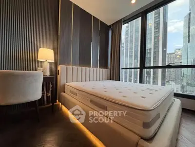 Luxurious bedroom with modern design and stunning city view from large windows.
