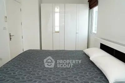 Modern bedroom with stylish wardrobe and large window for natural light.