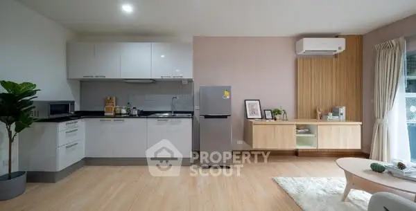 Modern open-layout kitchen and living room with sleek appliances and stylish decor.