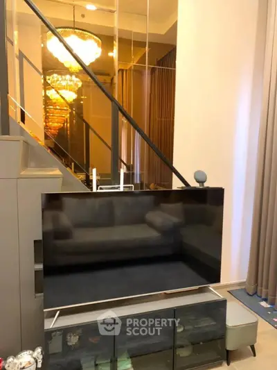 Luxurious living room with modern TV setup and elegant chandelier lighting