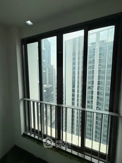 High-rise apartment balcony with cityscape view through large windows.