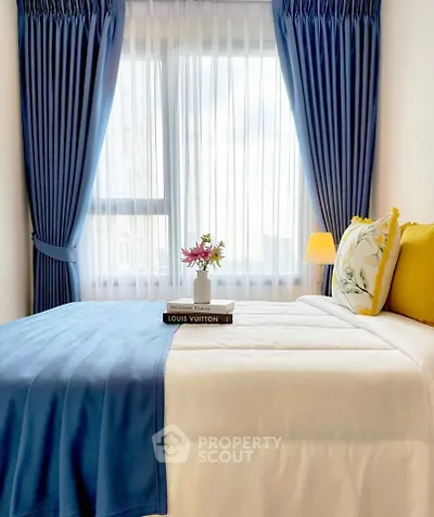 Cozy bedroom with elegant blue curtains and stylish decor, perfect for relaxation and comfort.