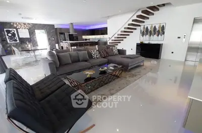 Luxurious modern living room with sleek furniture and open kitchen layout