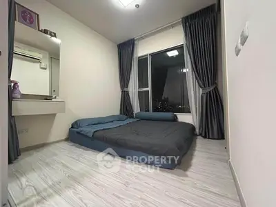 Cozy bedroom with modern decor and city view, featuring a comfortable bed and elegant curtains.