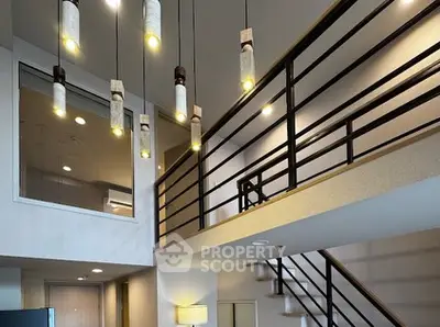 Modern loft with stylish lighting and open staircase, perfect for contemporary living.