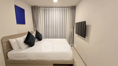 Modern minimalist bedroom with sleek design and wall-mounted TV
