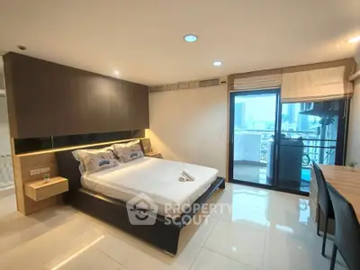 Modern bedroom with city view and balcony access, featuring sleek design and ample natural light.