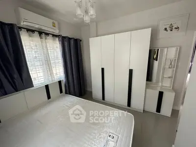 Modern bedroom with sleek white furniture and air conditioning