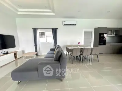 Spacious modern living room with sleek furniture and open kitchen layout