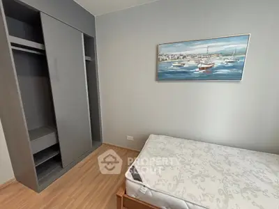 Cozy bedroom with built-in wardrobe and nautical artwork, perfect for modern living.