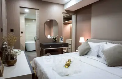 Luxurious bedroom with ensuite bathroom and elegant decor in modern apartment.