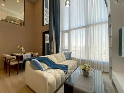 Luxurious high-ceiling living room with elegant decor and large windows