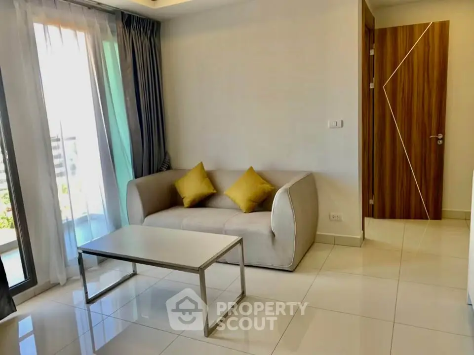 Modern living room with stylish sofa, coffee table, and large window for natural light.